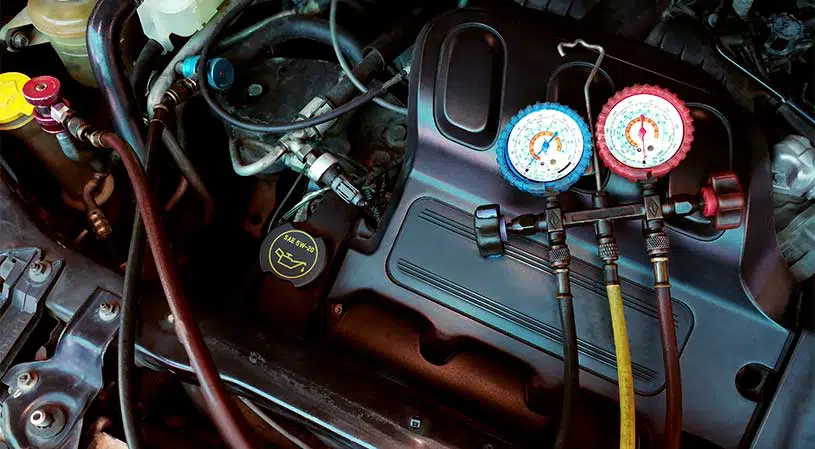 Air conditioning gauges connected during a car aircon regas service.