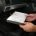 Mechanic replacing a car cabin air filter behind the glovebox.
