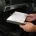 Mechanic replacing a car cabin air filter behind the glovebox.