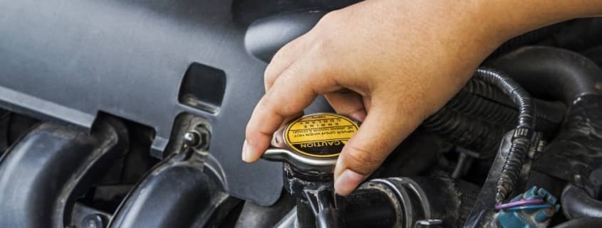 person turning car radiator cap