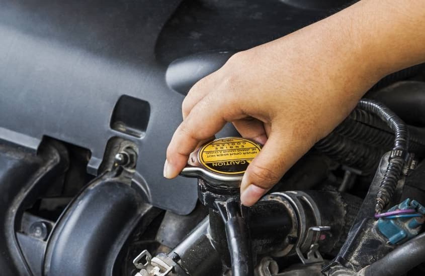 person turning car radiator cap