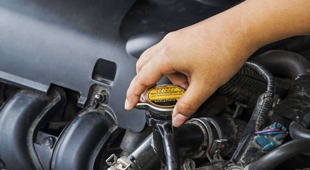 person turning car radiator cap