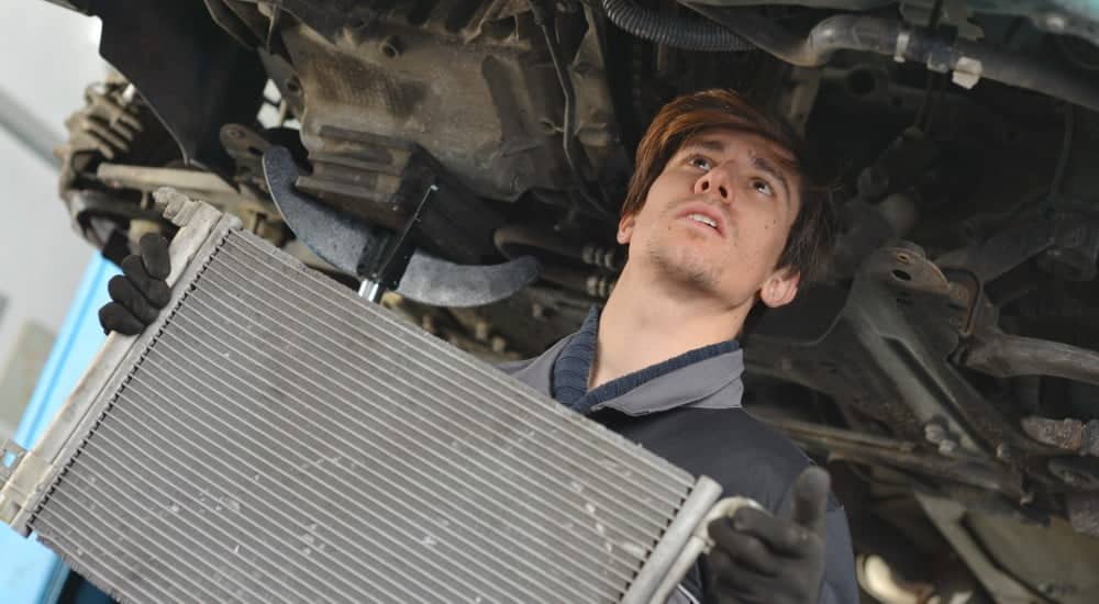 mechanic replacing corroded radiator