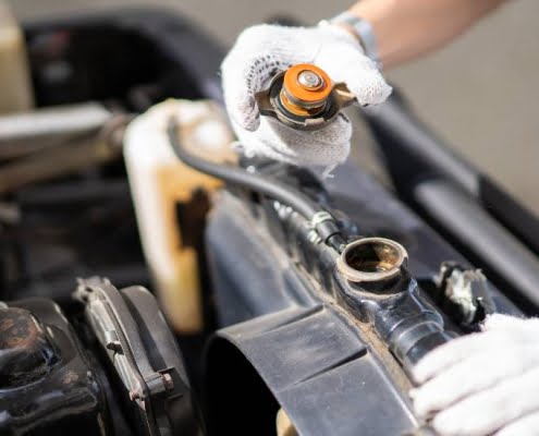 Car repair man checking the coolant system
