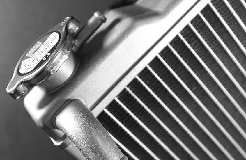 A close-up of the cap on a car radiator.
