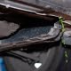 Close-up of green coolant leaking from under a car radiator, showing signs of a leaking radiator and cooling system damage.
