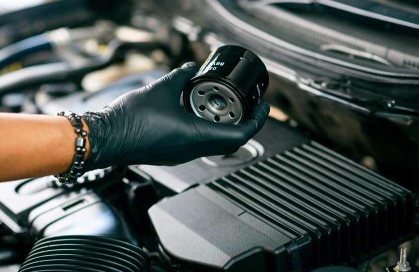 mechaninc changing an engine oil filter