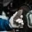 Mechanic holding a worn brake pad beside a car brake rotor.