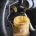 Closeup of a mechanic pouring fresh, clear brake fluid into the master cylinder of a vehicle.