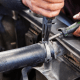 Mechanic removing a radiator hose during a car radiator replacement.