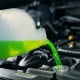 A mechanic pouring coolant directly into a car’s radiator
