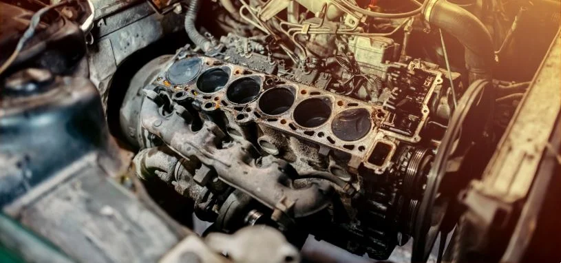 Uma junta de cabeçote de motor de carro danificada e com aparência enferrujada.