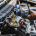 Car mechanic pouring engine oil into vehicle during doing car maintenance in garage
