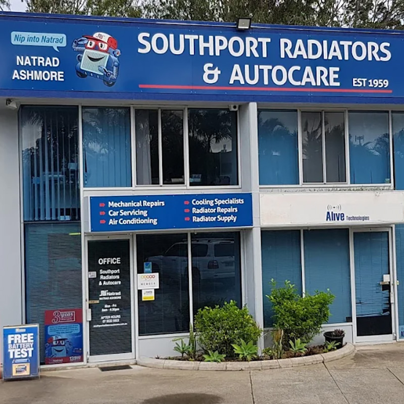 The exterior of our radiator repair centre featuring a blue storefront, large glass windows, and a service list sign.